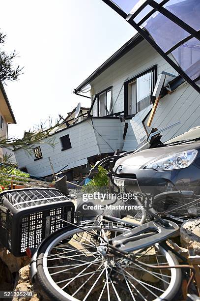 Bicycle and a car are seen by the collapsed house a day after the 2016 Kumamoto Earthquake on April 15, 2016 in Mashiki, Kumamoto, Japan. As of April...