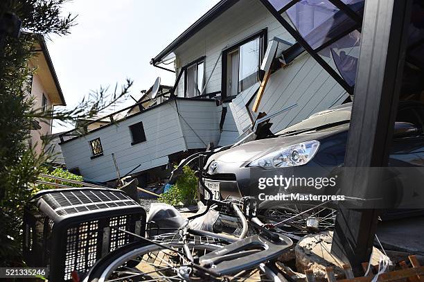 Bicycle and a car are seen by the collapsed house a day after the 2016 Kumamoto Earthquake on April 15, 2016 in Mashiki, Kumamoto, Japan. As of April...