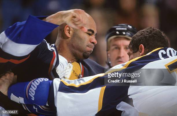 Donald Brashear of the Vancouver Canucks prepares to throw a punch at Nashville Predators forward Patrick Cote during a game at the Gaylord...
