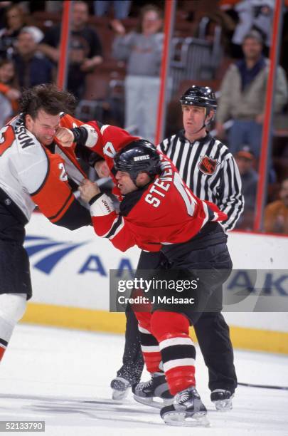 Canadian pro hockey player Scott Stevens of the New Jersey Devils, punches Philadelphia Flyer defenseman Luke Richardson in the face during a fight...