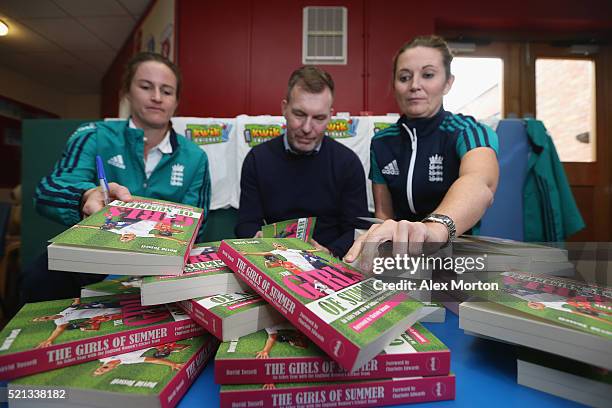 Lydia Greenway of England, author David Tossell and England captain Charlotte Edwards sign copies of Dovid Tossell's book during a media event to...