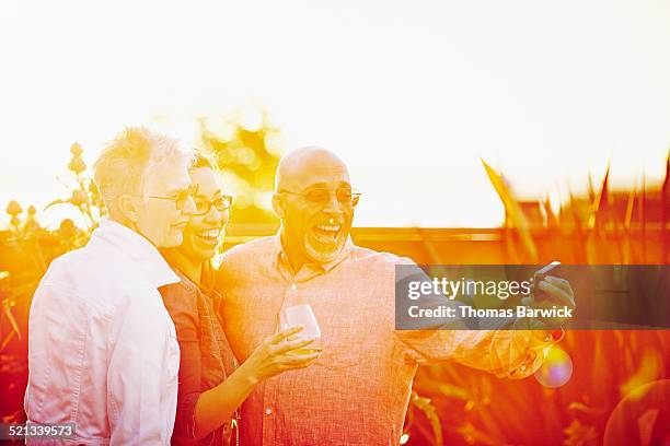 Three mature friends at party taking self portrait