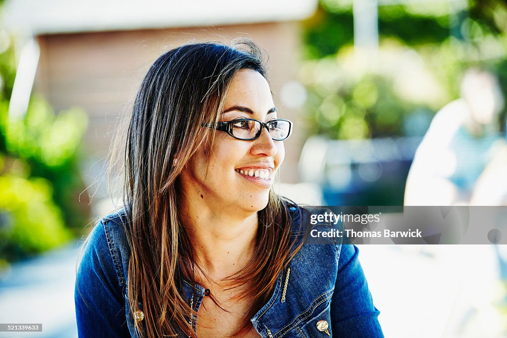 Smiling woman sitting on patio on summer afternoon