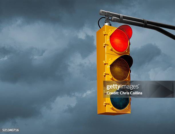 red light against overcast sky - red light stock-fotos und bilder