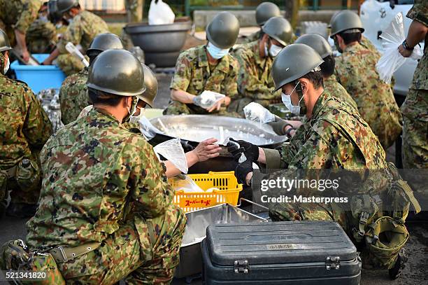 Members of the Japan Self-Defense Forces make rice balls at the soup-run operated at the evacuation center a day after the 2016 Kumamoto Earthquake...