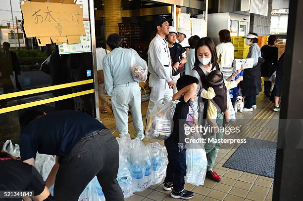 People receive relief supplies at the evacuation center a day after the 2016 Kumamoto Earthquake at the Mashiki Town Hall on April 15, 2016 in...