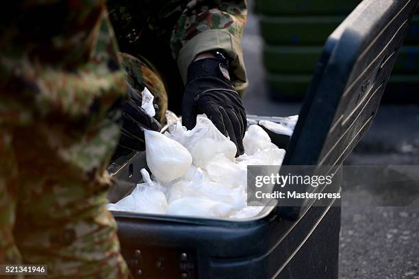 Member of the Japan Self-Defense Forces stores rice balls in a coolbox at the soup-run operated at the evacuation center a day after the 2016...