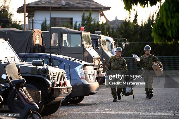 The Japan Self-Defense Forces members carry relief supplies for a soup-run at the evacuation center a day after the 2016 Kumamoto Earthquake at the...