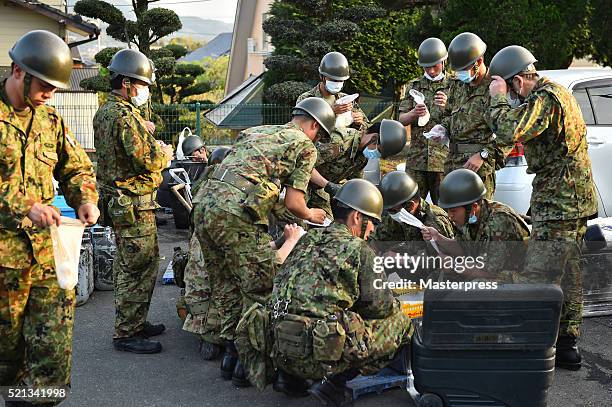 The Japan Self-Defense Forces members make rice balls at a soup-run operated at the evacuation center a day after the 2016 Kumamoto Earthquake at the...