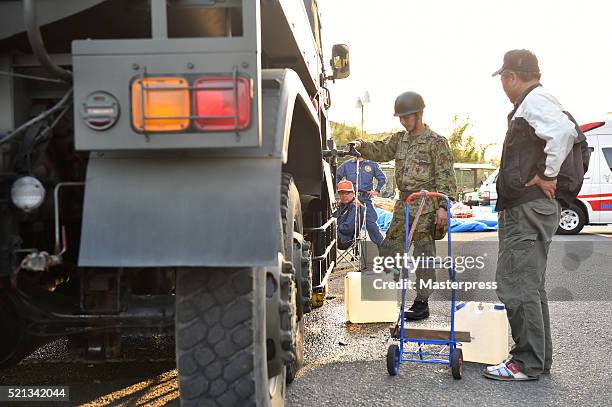 Member of the Japan Self-Defense Forces works at the relief water supply station a day after the 2016 Kumamoto Earthquake at the Mashiki Town Hall on...
