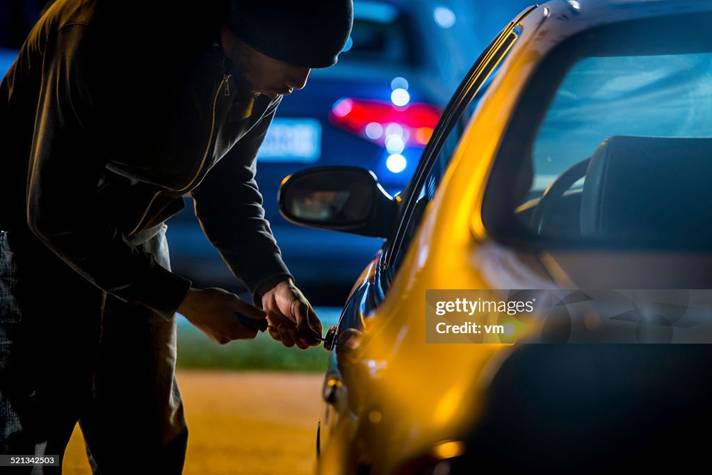 Car Thief Using a Screwdriver to Brake into a Car