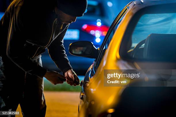 car thief using a screwdriver to brake into a car - inbrott bildbanksfoton och bilder