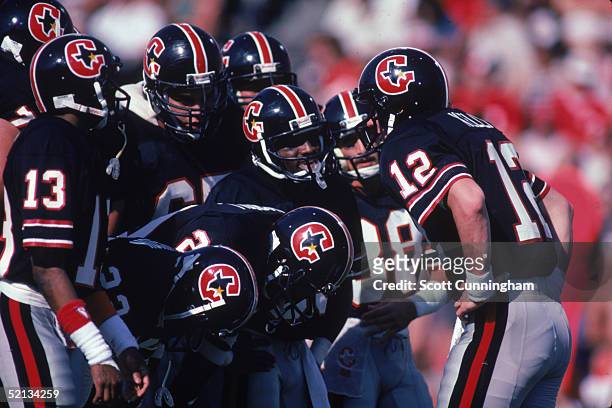Quarterback Jim Kelly of the Houston Gamblers stands with his team in a huddle during a 1985 season USFL game.