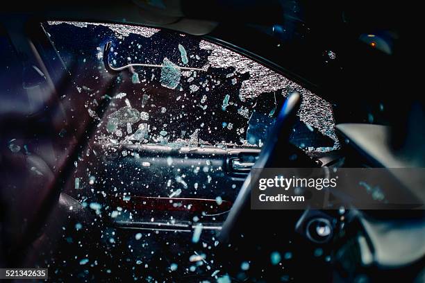 car thief breaking car window - stal stockfoto's en -beelden