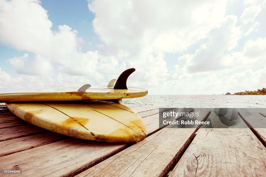 Surfboards laying on a Caribbean resort dock in Belize