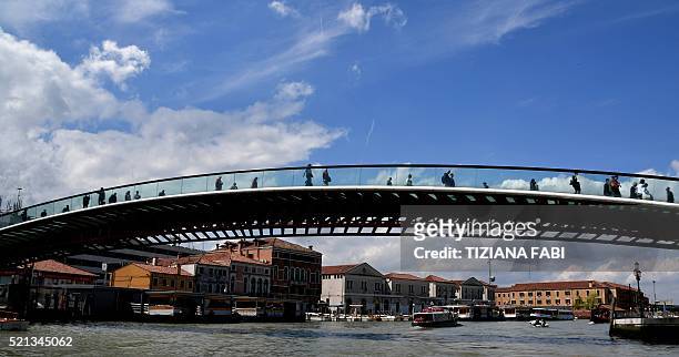 Photo taken on April 15, 2016 shows people walking across the Constitution Bridge which spans the Grand Canal in Venice. AFP PHOTO / TIZIANA FABI The...