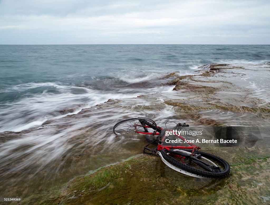 Broken and abandoned bicycle by the sea