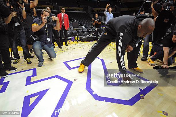 Kobe Bryant of the Los Angeles Lakers signs the court after his last game against the Utah Jazz at STAPLES Center on April 13, 2016 in Los Angeles,...