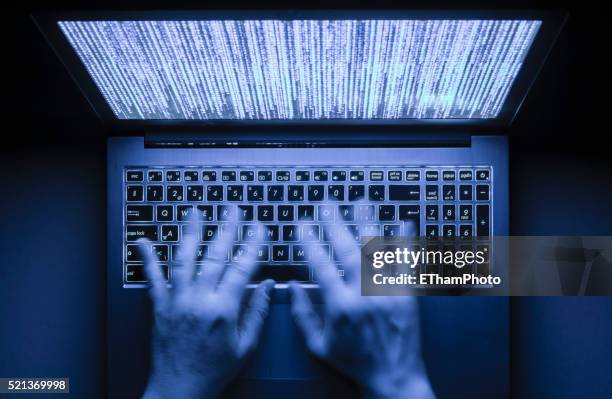 illuminated laptop computer in the dark - encryption stock pictures, royalty-free photos & images