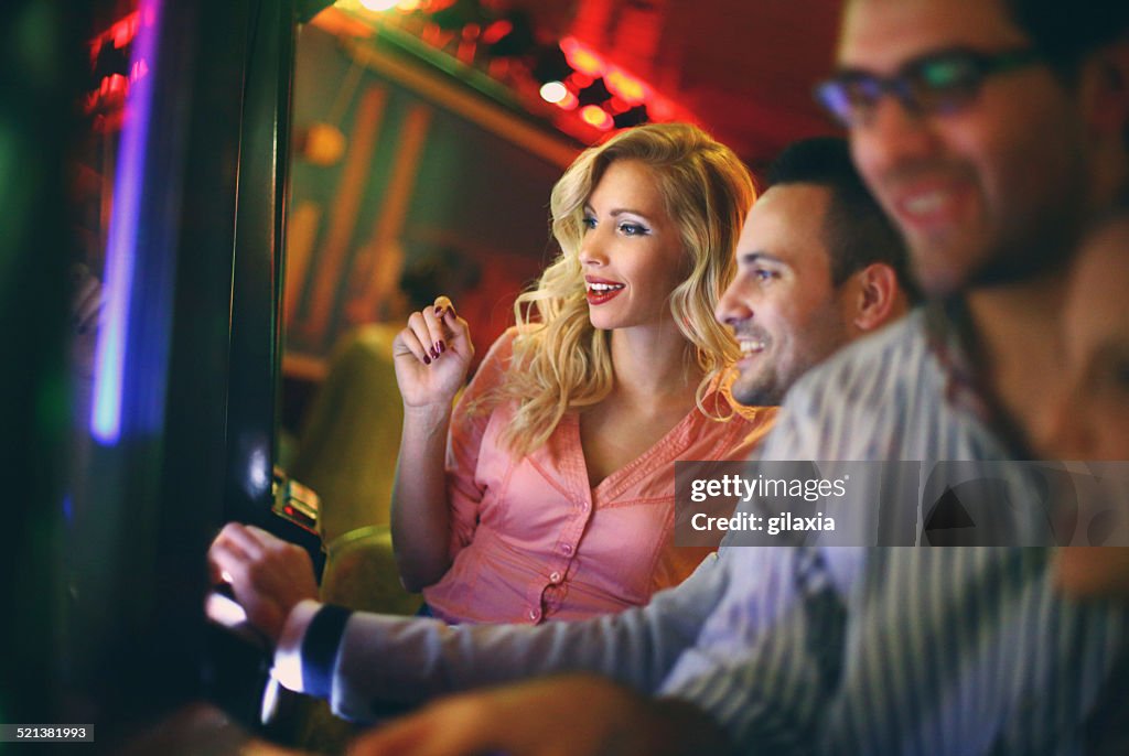 Group of people playing slots in casino.