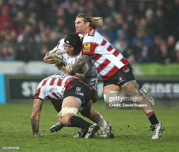 Harry Williams of Exeter is tackled by Ross Moriarty and Richard Hibbard during the Aviva Premiership match between Gloucester and Exeter Chiefs at...