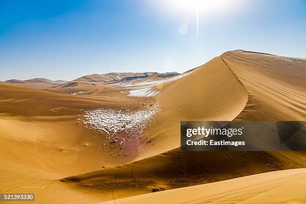 sand dunes with snow in the desert, dunhuang, gansu province, china - landelement stockfoto's en -beelden