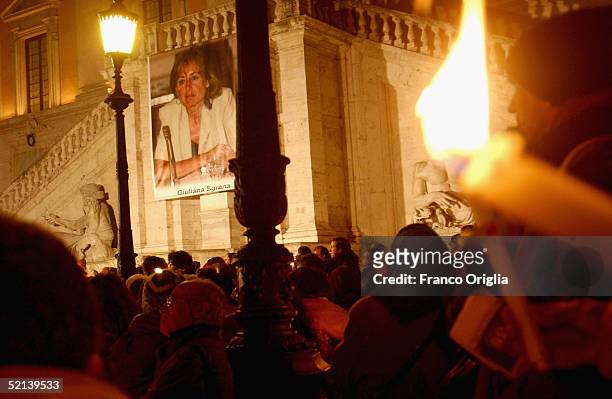 People hold candles during a meeting of solidarity for kidnapped journalist Giuliana Sgrena in the Capitole Square on February 5 in Rome, Italy....
