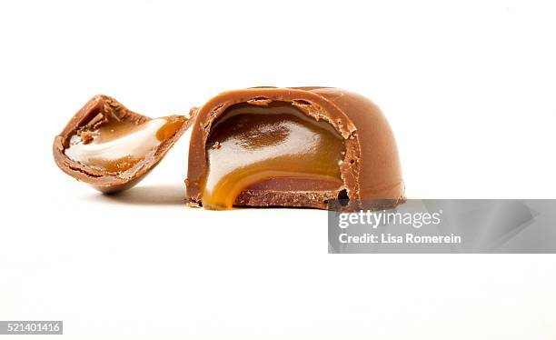 open chocolate candy with caramel dripping out - chocolate caramel stock pictures, royalty-free photos & images