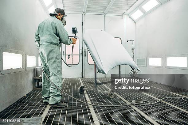 mechanic in painting booth spray the hood of a car - spray booth stock pictures, royalty-free photos & images