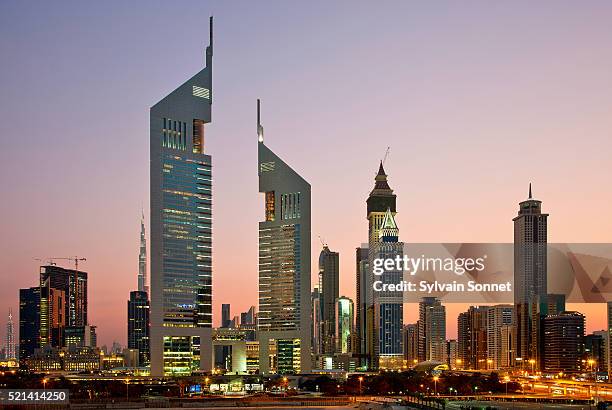 dubai, emirates towers and skyscrapers at dusk - emirates towers stock pictures, royalty-free photos & images