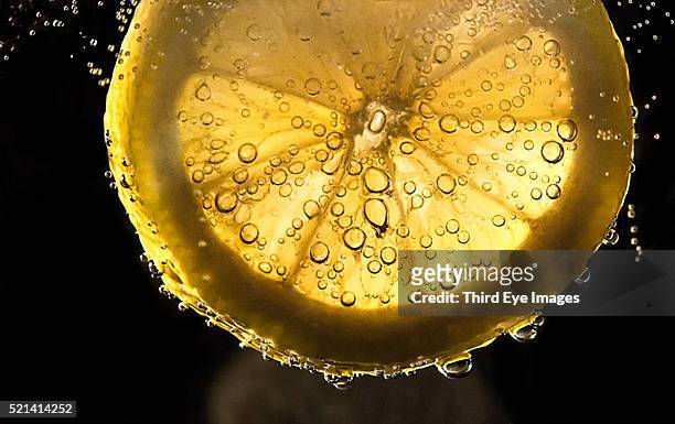 studio shot of lemon falling into water - citrus splash stock pictures, royalty-free photos & images