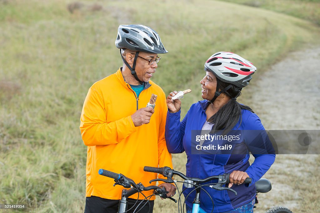 African American couple with bikes, eating snack