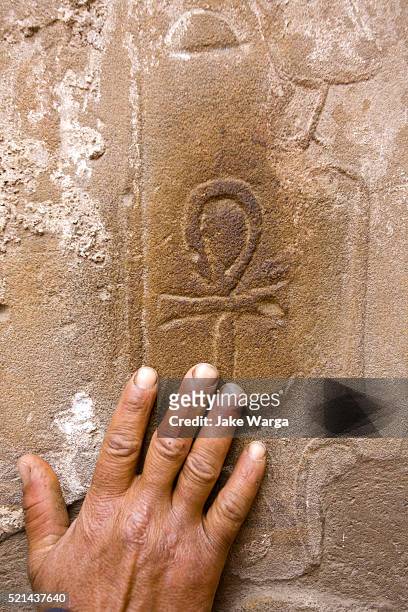 man rubbing onk symbol, luxor, egypt - jake warga stock pictures, royalty-free photos & images