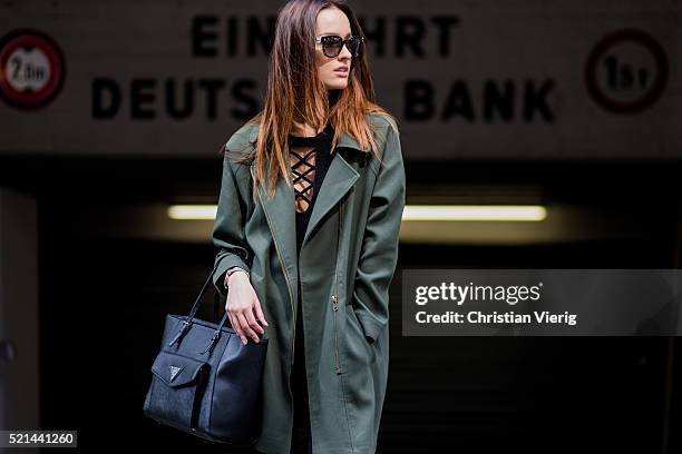 Fashion model Jueli Mery a green jacket from Forever 21, a black Topshop top, black denim jeans from Zara and a black Guess bag April 14, 2016 in...
