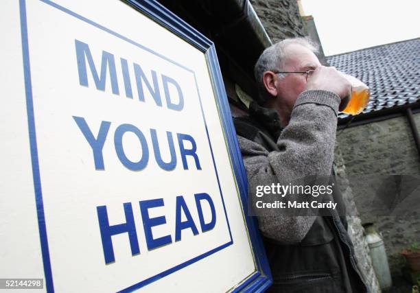 Drinker enjoys a pint in Tucker's Grave, a traditional cider pub, February 5 Faulkland, Somerset, England. Regulars in the pub known for its stong...