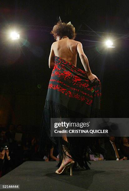 Model wears a creation with shawls by Spanish designer Manos Bordadoras during the Simof 'Salon International of Flamenco Fashion' show at the...