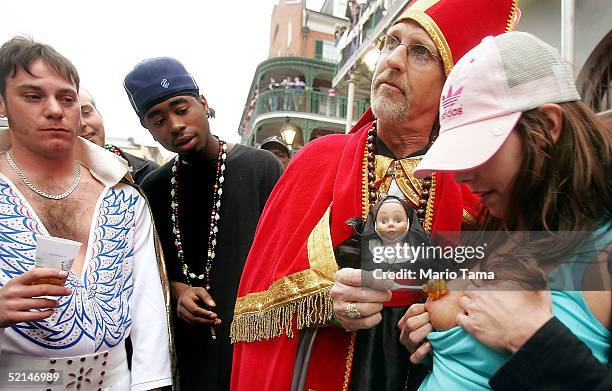 Man dressed as the Pope "blesses" a woman as revelers, including an Elvis impersonator, looks on during Mardi Gras festivites February 6, 2005 in New...