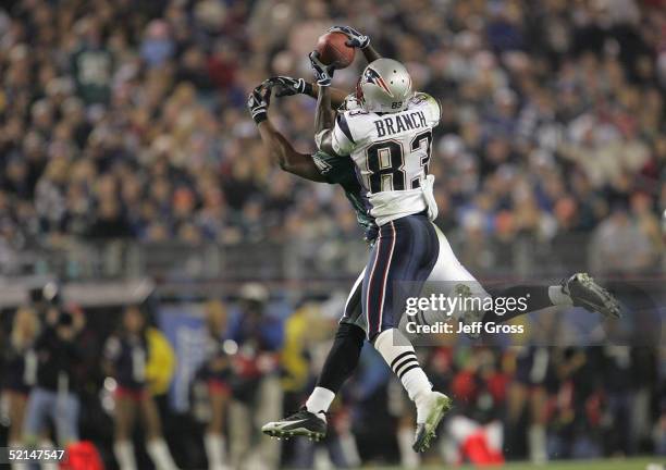 Wide receiver Deion Branch of the New England Patriots catches a Super Bowl record 11th pass of the game over the outstretched arms of cornerback...