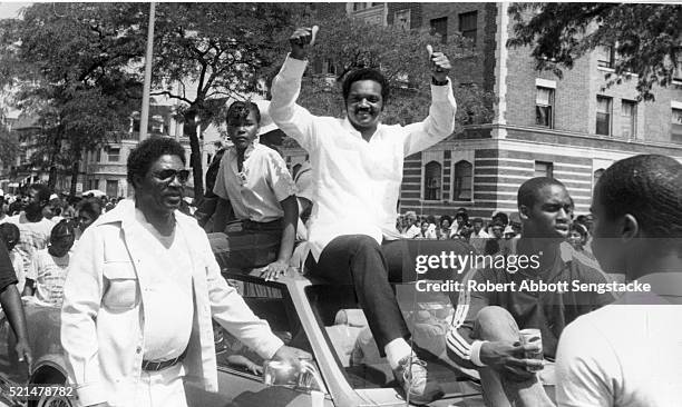American religious and Civil Rights leader and politician Jesse Jackson gives a 'thumbs up' as he greets supporters from the roof of an car during...