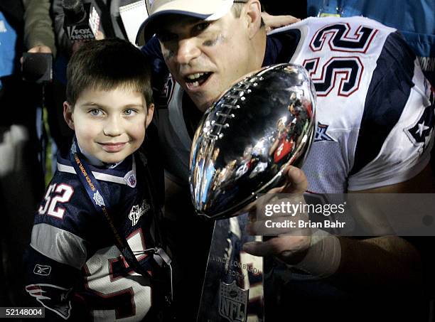 Ted Johnson of the New England Patriots poses with his son after defeating the Philadelphia Eagles in Super Bowl XXXIX at Alltel Stadium on February...