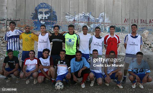 Palestinian youth pose for a picture in a football pitch next to a section of Israels separation barrier, in the west bank village of Abu Dis, in...