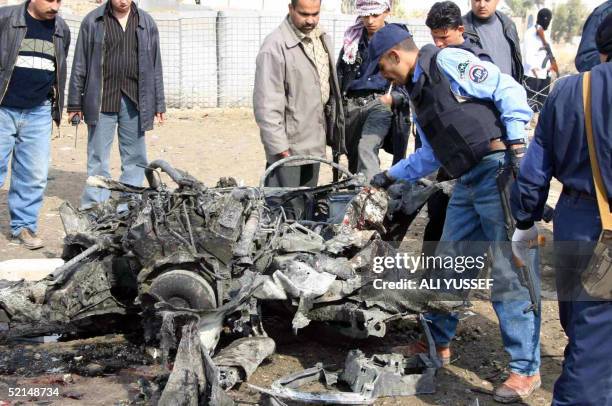 Iraqi policemen inspect what's left of a car bomb outside the Diyala province Police headquarters 07 February 2005 in Baquba, 60 km north of Baghdad....