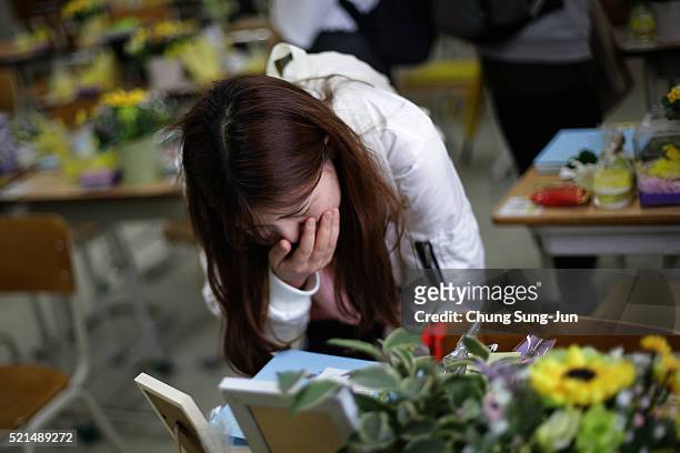 South Korean woman mourns for victims of the Sewol ferry in a second year classroom at Danwon High School on April 16, 2016 in Ansan, South Korea. In...