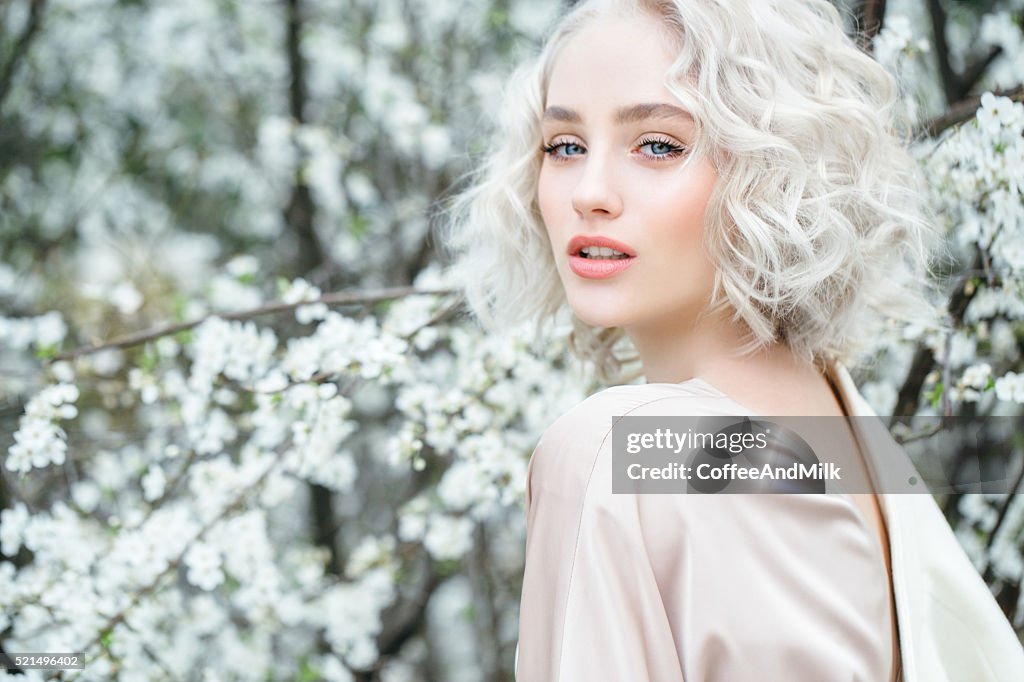 Beautiful girl on the background of spring bush