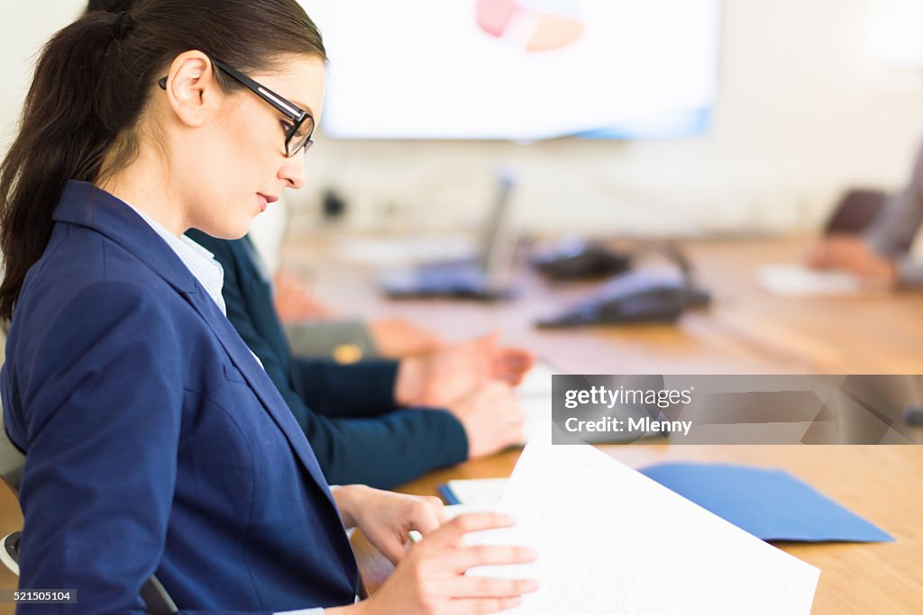 Documents de lecture de femme d'affaires dans la salle de réunion