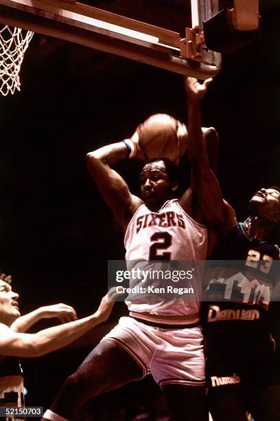 Moses Malone of the Philadelphia 76ers drives to the basket against the Denver Nuggets during an NBA game in 1983 at the Spectrum in Philadelphia,...