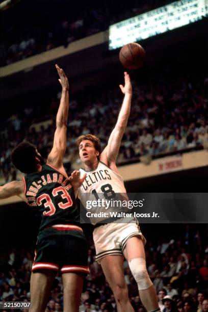 Dave Cowens of the Boston Celtics shoots a hook shot against the Kareem Abdul-Jabbar of the Milwaukee Bucks during an NBA game at the Boston Garden...