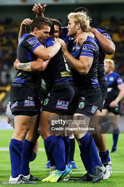 Sam Perrett of the Bulldogs is congratulated by teammates Kerrod Holland and Aiden Tolman after scoring a try during the round seven NRL match...