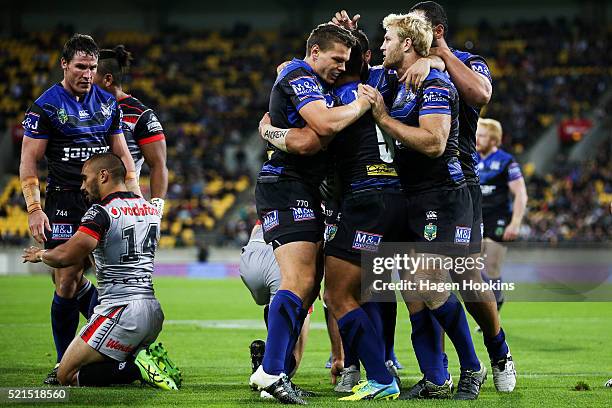 Sam Perrett of the Bulldogs is congratulated by teammates Kerrod Holland and Aiden Tolman after scoring a try during the round seven NRL match...