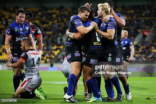 Sam Perrett of the Bulldogs is congratulated by teammates Kerrod Holland and Aiden Tolman after scoring a try during the round seven NRL match...